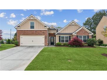 Charming single-Gathering home featuring a brick facade, well-manicured lawn, and an attached two-car garage at 4580 Orchard Ridge Ct, Cumming, GA 30028