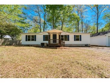 Charming single-story home featuring white siding, dark blue shutters, and a welcoming front porch at 56 Windom Dr, Carrollton, GA 30116