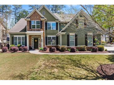 Charming two-story home with a stone accent wall, landscaped yard, and manicured lawn at 602 Redbud Ter, Canton, GA 30115