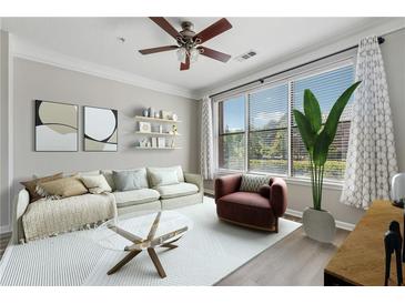 Bright living room featuring large windows, ceiling fan, neutral decor, and modern furnishings at 400 17Th Nw St # 2029, Atlanta, GA 30363