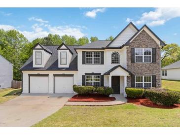 Charming two-story home featuring stone accents, a two-car garage, and a well-manicured front lawn at 3791 Plantation Mill Dr, Buford, GA 30519