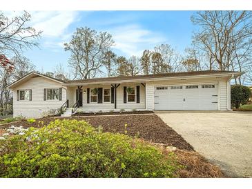 Charming one-story home with a two-car garage, black shutters, and manicured landscaping at 4646 Mountain Creek Ne Dr, Roswell, GA 30075