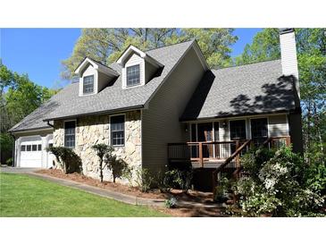 Charming home featuring a stone facade, dormer windows, and a inviting front deck at 1521 Larkwood Dr, Canton, GA 30114