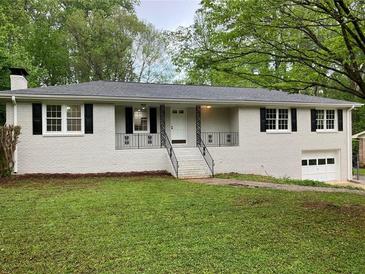 Charming home with a white brick facade, black shutters, and a well-maintained lawn at 1871 Kinridge Rd, Marietta, GA 30062