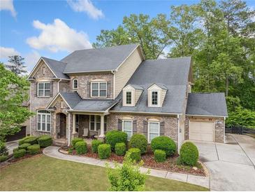 Beautiful brick two-story home with manicured lawn and attached garage in a desirable neighborhood at 626 Oakbourne Way, Woodstock, GA 30188