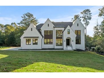 Stunning white painted home with black trim and modern windows on a lush green lawn at 584 Indian Hills Pkwy, Marietta, GA 30068