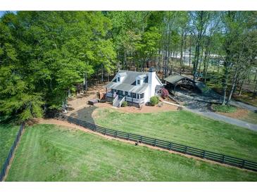 Charming home featuring a large, grassy yard, a quaint front porch, and a convenient carport at 8132 Union Hill Rd, Canton, GA 30115