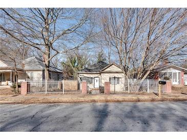 Charming single-story home featuring a fenced yard, mature trees, and inviting curb appeal at 1415 Eric Se St, Atlanta, GA 30315