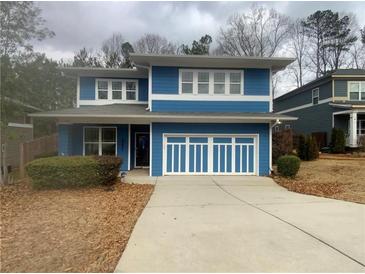 Charming two-story home featuring a blue exterior, well-maintained landscaping, and a spacious driveway at 2331 Bouldercliff Se Way, Atlanta, GA 30316