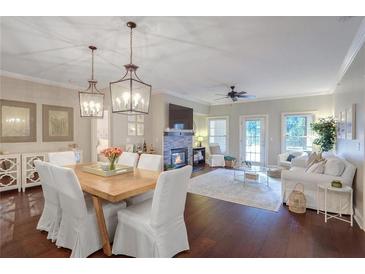Open-concept living and dining room with hardwood floors, fireplace, and modern lighting at 211 Colonial Homes Nw Dr # 2106, Atlanta, GA 30309