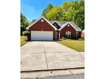 Charming brick home with a well-maintained lawn and a spacious driveway at 2608 Cascade Cove Dr, Buford, GA 30519