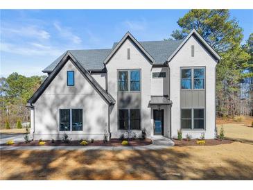 Beautiful two story white brick home with large windows and manicured landscaping at 3735 Tamiami Trl, Cumming, GA 30041