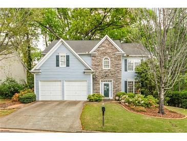 Charming two-story home with stone accents, lush landscaping, and a well-manicured lawn at 4034 Brockett Walk, Tucker, GA 30084