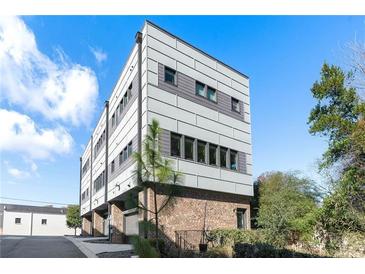 Modern townhome featuring a brick facade and architectural paneling, complemented by professional landscaping and mature trees at 611 King Arnold St, Atlanta, GA 30354