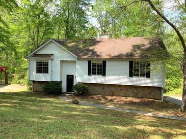 Charming single-Gathering home with a well-maintained lawn and mature trees creating a private, wooded setting at 997 Timbervale Ln, Lithonia, GA 30058