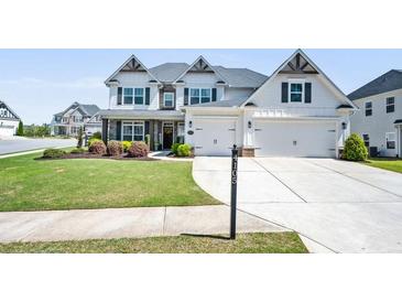 Beautiful two-story home featuring a manicured lawn, stone accents, and a two-car garage at 4105 Woodwind Dr, Cumming, GA 30028