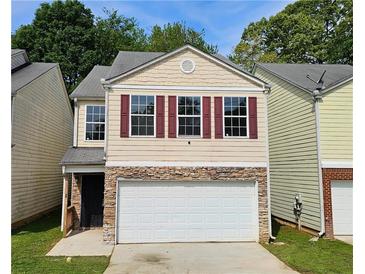 Charming home with stone accents, a two-car garage, and manicured lawn at 5169 Hanover St, Atlanta, GA 30349