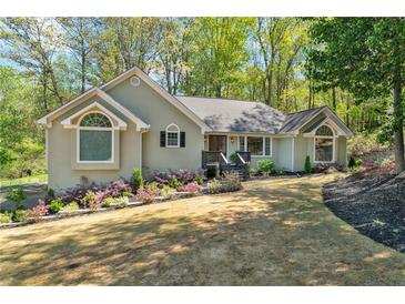 Charming single story home with well-maintained landscaping and inviting curb appeal on a sunny day at 1819 Yorkshire Dr, Woodstock, GA 30189
