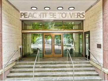 The Peachtree Towers entrance has stone steps and a glass door leading into the building at 300 Peachtree Ne St # 21H, Atlanta, GA 30308