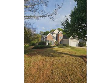 Charming two-story home with a brick facade and a well-manicured front lawn at 2012 Grove Park Ct, Marietta, GA 30062