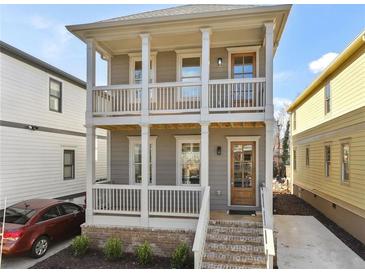 Charming two-story home featuring a welcoming front porch with white railings and a brick foundation at 106 Hogue St, Atlanta, GA 30312