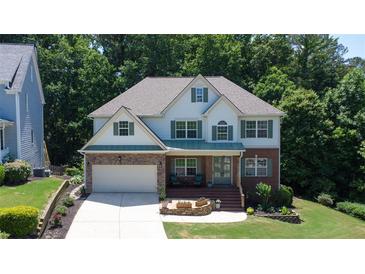 Charming two-story home featuring a blend of brick and siding, with a well-manicured lawn and inviting front porch at 6765 Creek View Ln, Cumming, GA 30041