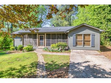 Charming home with a screened front porch, stone walkway, and beautifully landscaped front yard at 1878 Suwanee Roberts Ct, Lawrenceville, GA 30043