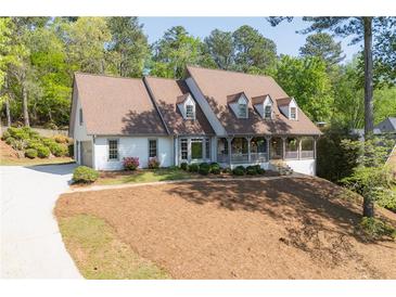Charming home featuring a welcoming front porch and a well-manicured front yard at 7700 Dunvegan Close, Atlanta, GA 30350