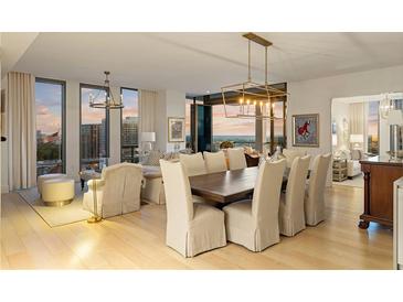 Bright dining and living room area with city views, natural light, modern decor and beautiful hardwood flooring at 3107 Peachtree Ne Rd # 1403, Atlanta, GA 30305