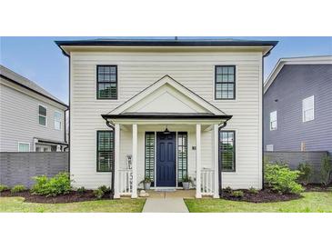 Charming two-story home featuring a blue front door, a cozy porch, and manicured landscaping at 89 Little Magnolia Ln, Auburn, GA 30011