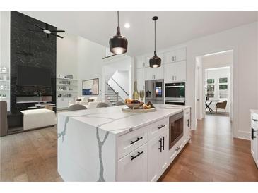 Bright, open kitchen with a large island, stainless steel appliances, and hardwood floors at 3950 Clifton Hill Court #13, Cumming, GA 30040