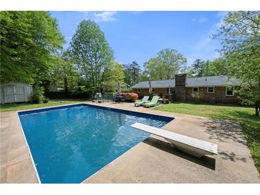 Backyard pool featuring a diving board and surrounding patio, perfect for outdoor enjoyment at 690 Manor Ridge Sw Dr, Mableton, GA 30126