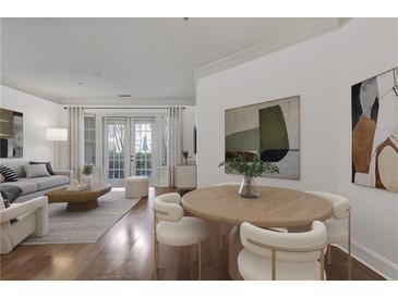 Bright living room features hardwood floors, neutral decor, and access to the outdoors through French doors at 3621 Vinings Slope Se # 3204, Atlanta, GA 30339