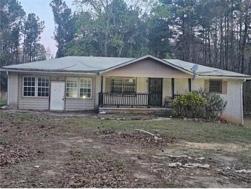Modest single-story brick home with mature trees and a covered front porch at , Stockbridge, GA 30281
