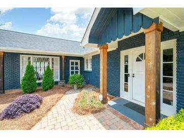Charming home exterior featuring brick facade, lush landscaping, and a welcoming entrance at 2155 Old Dallas Rd, Marietta, GA 30064