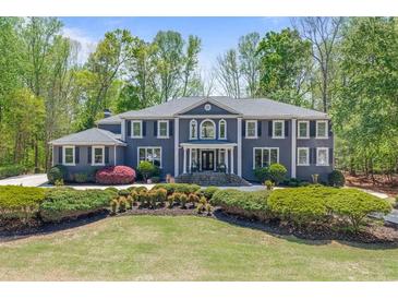 Stately two-story home featuring symmetrical design, manicured landscaping, and elegant columns at 335 Birkdale Dr, Fayetteville, GA 30215