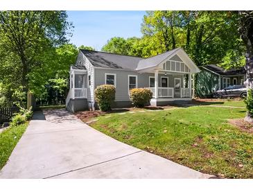 Charming home with a well-maintained lawn, inviting front porch, and a long driveway leading up to the house at 1084 Regent Sw St, Atlanta, GA 30310
