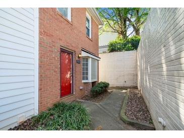 Brick two-story townhome featuring a red door and exterior window at 200 High Creek Dr, Roswell, GA 30076