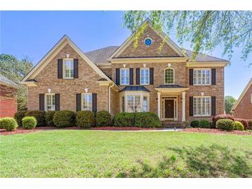 Elegant brick home with manicured lawn and mature landscaping offers great curb appeal at 562 Grassmeade Way, Snellville, GA 30078