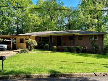 Charming brick home featuring a lush green lawn, carport and classic design at 2292 1St Ne Ave, Atlanta, GA 30317