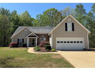 Charming single-Gathering home featuring a well-manicured lawn and attached two-car garage at 5668 Blanchard Pl, Sugar Hill, GA 30518