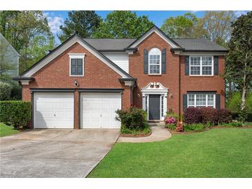 Charming two-story brick home with a well-manicured lawn and a two-car garage at 3925 Tugaloo River Dr, Duluth, GA 30097