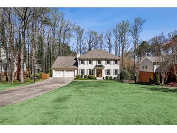 Charming two-story home with a well-manicured lawn, attached garage, and traditional architectural details at 4765 Karls Gate Dr, Marietta, GA 30068