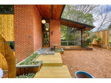 Striking brick home with a wood-plank walkway, modern lighting, and expansive windows at 151 Rockmart Dr Sw, Atlanta, GA 30314