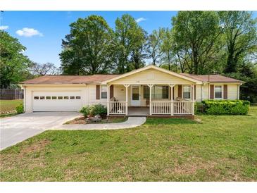 Charming one-story home features a welcoming front porch and attached garage, nestled on a lush green lawn at 645 Camp Perrin Rd, Lawrenceville, GA 30043
