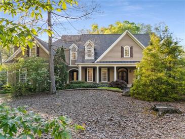 Charming two-story home with a covered front porch, manicured landscaping, and beautiful curb appeal at 6050 Providence Ln, Cumming, GA 30040