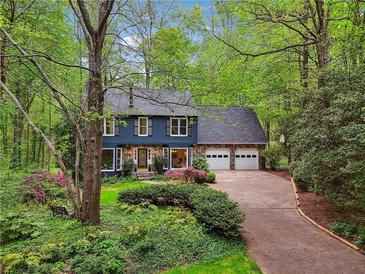 Charming two-story home with a stone accents, a two-car garage, and mature landscaping at 3988 Dover Ave, Alpharetta, GA 30009
