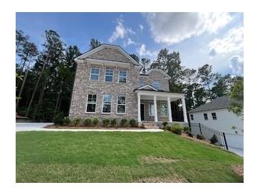 New two-story brick home boasts a manicured lawn and welcoming covered porch at 4520 Ajo Walk, Atlanta, GA 30331