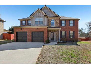 Inviting two-story brick home featuring a two-car garage and well-maintained lawn on a sunny day at 4316 Constellation Blvd, Snellville, GA 30039