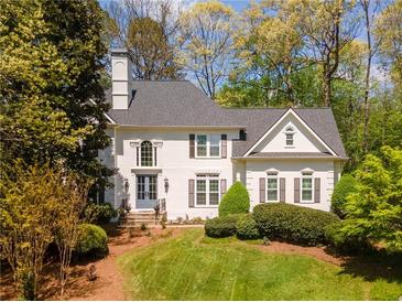 Charming two-story white home with manicured lawn and mature trees in a desirable neighborhood at 129 Ridgetree Ln, Marietta, GA 30068